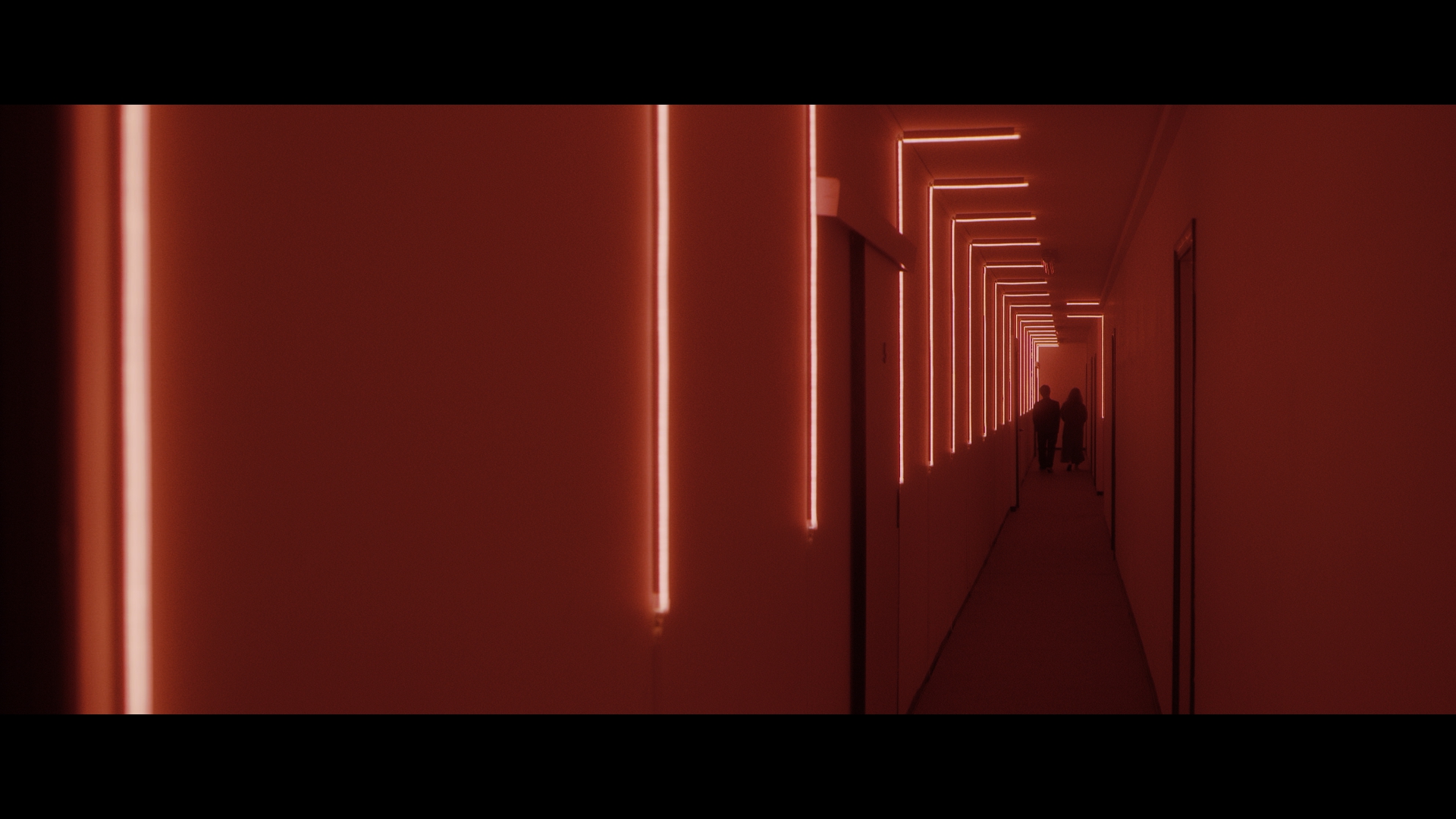 Silhouette of a cinematographer with a cinema camera in moody amber light